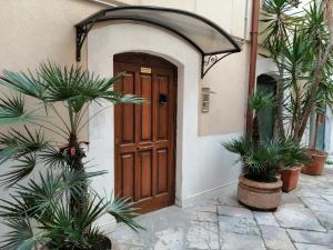 a door to a house with palm trees in front of it at Corte Del Borgo Antico in Bari