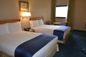 a hotel room with two beds and a window at Holiday Inn Yanbu, an IHG Hotel in Yanbu