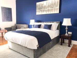 1 dormitorio con 1 cama grande y pared azul en The Bank Hotel & Bistro en Hastings