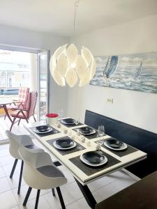a dining room table with plates and glasses on it at Apartment Bonaca in Portorož