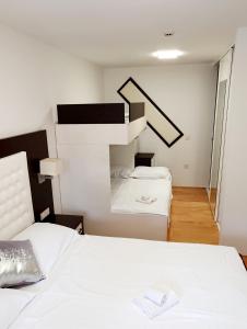 a bedroom with a white bed and a staircase at Apartment Bonaca in Portorož