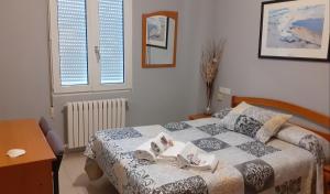 um quarto com uma cama com duas toalhas em Hostal Monteclaro em Ponferrada