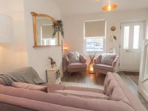 a living room with a couch and two chairs and a mirror at Hope Cottage in Hythe