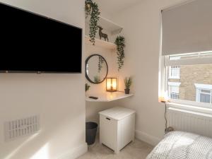 a bedroom with a flat screen tv on a wall at Hope Cottage in Hythe
