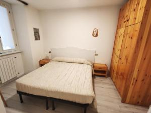 1 dormitorio con 1 cama y puerta de madera en Al Ponte Nuovo, en Ponte di Legno