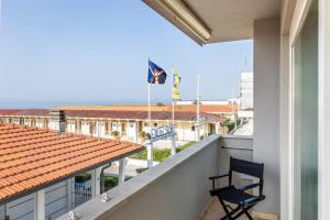 een balkon met een stoel en een vlag op een gebouw bij Viareggio Suite - Sea view apartment in Viareggio