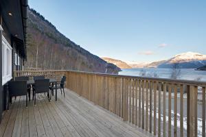 a wooden deck with a table and chairs on it at Hardangerpark AS in Kinsarvik