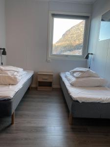 two beds in a room with a window at Hardangerpark AS in Kinsarvik