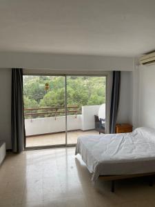 una camera con un letto e una grande finestra in vetro di Nice Studio in Siesta 2 in Puerto Alcudia 8 a Alcudia