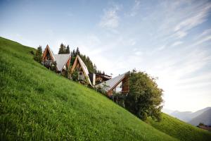 a house on the side of a green hill at HochLeger - Chalet Refugium am Berg in Aschau