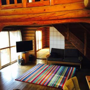 a living room with a couch and a flat screen tv at NaGano-log house in Chino