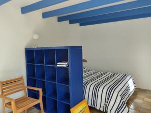 een slaapkamer met een blauwe kast en een bed bij Petite maison du manoir de Keryvoas in Kerlouan