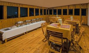 ein Esszimmer mit Tischen, Stühlen und Fenstern in der Unterkunft Treebo Trend Omega Stay Inn in Shillong