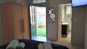 una sala de estar con una puerta que da a una cocina en T2 D en coeur de Balaruc dans maison avec jardin ideal couple de curistes en Balaruc-les-Bains