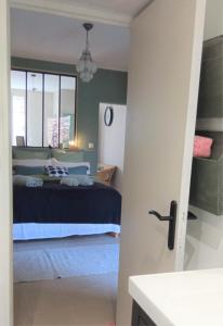 1 dormitorio con cama y ventana en T2 D en coeur de Balaruc dans maison avec jardin ideal couple de curistes en Balaruc-les-Bains