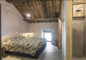 a bedroom with a bed and a wooden ceiling at La Grange de Victor in Léglise