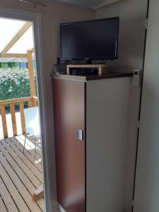 TV en la parte superior de una nevera en una habitación en MOBILHOME agréable sans draps ni serviettes, en Port-la-Nouvelle
