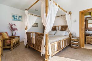 une chambre avec un lit à baldaquin avec des rideaux blancs dans l'établissement Villa Bali, à Playa Blanca 15 autres photos