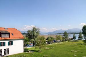 a house with an orange roof and a green yard at Hotel Aiterbach am Chiemsee in Rimsting