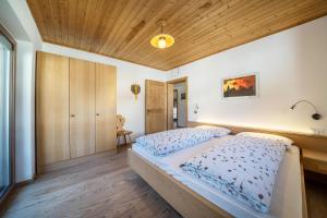 a bedroom with a bed and a wooden ceiling at Ferienwohnung Mittager Edelweiss in Avelengo