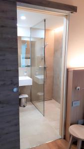 a bathroom with a glass shower and a sink at Livì Family Hotel in Livigno