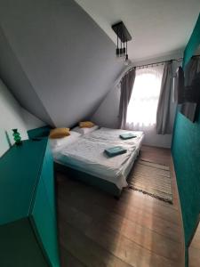 um pequeno quarto com uma cama e uma janela em Reitz Vendégház em Villány