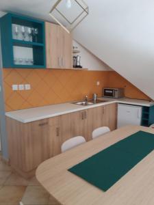 a kitchen with a sink and a table with chairs at Reitz Vendégház in Villány