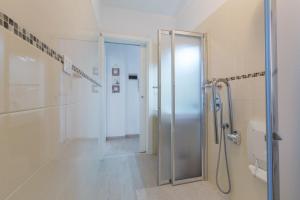 a bathroom with a shower and a glass door at Lido di Spina vista mare pineta - A Casa di Alessandra in Lido di Spina