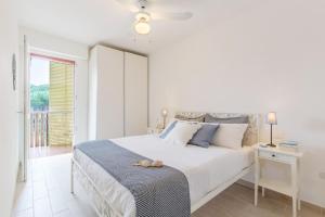 a white bedroom with a large bed and a window at Lido di Spina vista mare pineta - A Casa di Alessandra in Lido di Spina