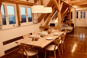 a wooden table and chairs in a room with windows at Zum Alten Backhaus in Burg