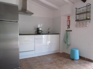 a kitchen with white cabinets and a stainless steel refrigerator at Nova Alofa holiday home in Monchique