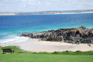 a bench on a beach near the ocean at The Western in St Ives