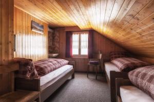 um quarto com 2 camas num chalé de madeira em Rigi-Burggeist Alpine Guesthouse em Gersau