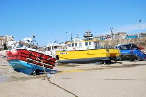 three boats sitting on the sand on the beach at The Western in St Ives