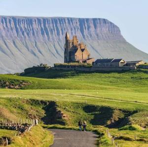 duas pessoas a andar por uma estrada em frente a um castelo em Herds House Belcoo em Belcoo