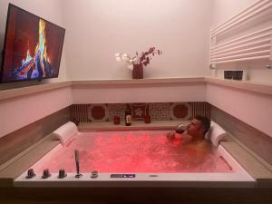 a man in a bath tub with a bottle of water at MAD SUITES & APARTMENTS in Bernalda