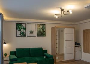 a living room with a green couch and a kitchen at Fargo in Ustka