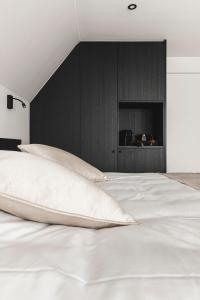 - une chambre avec un lit blanc et un mur noir dans l'établissement Salons Denotter, à Zedelgem