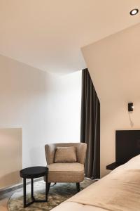 - une chambre avec une chaise et un lit dans l'établissement Salons Denotter, à Zedelgem