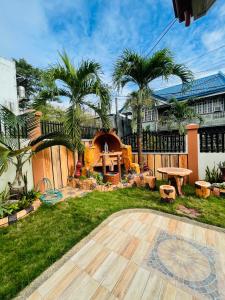 a backyard with a picnic table and palm trees at RESTHOUSE fully airconditioned w/ Private Parking in Tuguegarao City