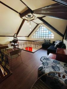 an attic room with a couch and a table at RESTHOUSE fully airconditioned w/ Private Parking in Tuguegarao City