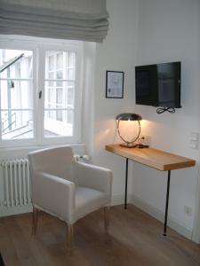 Cette chambre comprend un bureau, une chaise et une télévision. dans l'établissement Hotel Schnookeloch, à Heidelberg