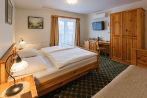 Habitación de hotel con cama y escritorio en Penzion Kaps en Bled