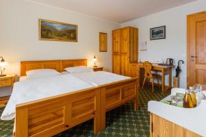 a bedroom with a large wooden bed and a desk at Penzion Kaps in Bled