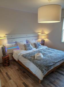 a bedroom with a large white bed with two lamps at l’Écrin du Verger in Baldersheim