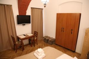 ein kleines Zimmer mit einem Tisch, einem TV und einem Zimmer in der Unterkunft Residence Krone in Braşov