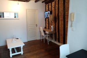 Zimmer mit einem Schreibtisch und einem Tisch mit Stühlen in der Unterkunft Meublé tourisme classé 1 étoile - coeur de ville quartier cathédrale in Tours