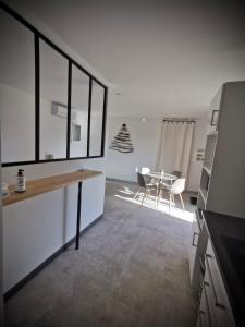 cocina y comedor con mesa y sillas en Lodging Gîte Au Milieu des Vignes & des Étoiles en Saint-Jean-de-Fos