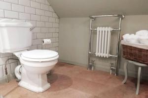 a bathroom with a toilet and a basket of towels at Horseshoe Cottage Greyabbey in Greyabbey