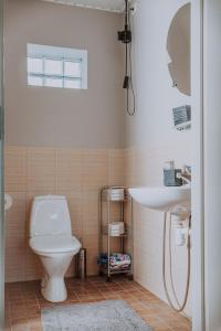 a bathroom with a toilet and a sink at Kevade Guesthouse with Sauna in Kuressaare